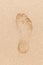 Human footprint in wet yellow sand