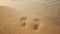 Human footprints on bare sand washes away by wave