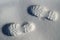 Human footprints boots reflected on the white snow in winter