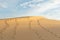 Human footprints on desert sand going towards horizon on hot sunny day