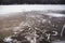 Human footprints on the surface of a frozen pond. Winter lake. Dangerous thin cracked ice