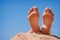 Human foots close-up relaxing on the beach