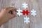 The human hand catches the white puzzle Pieces of red and white puzzle on a brown background. Business concept. Success and