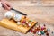 Human hand grinds christmas baubles by knife on wooden surface. Cooking or prepare Christmas, conceptual photo