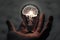 Human hand holding light bulb with glowing virtual brain