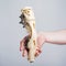 Human hand holding part of robotic mechanical bone prosthesis prototype. Bionic technology, beige human arm, engineering