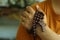 Human hand holding a rosary on the shoulder. Junior young man hands praying holding a rosary with Jesus Christ Cross or Crucifix.