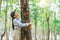 Human hand Hug and touching tree in the forest .people protect from deforestation and pollution or climate change Concept to love