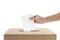 Human hand inserts vote paper into ballot box