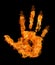 Human hand in orange flame on black