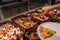 Human hand picking assorted food in luxury buffet meal