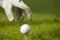 Human hand positioning golf ball on tee, close-up