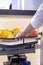 Human hand pushes the pull-out shelf with fresh lemons in the contemporary modern convenient kitchen cupboard