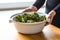 human hand serving kale chips in a white dish