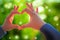 Human hand showing gesture love sign on fresh green nature