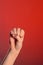 Human hand that squeezed fingers into a fist, symbolizing hatred and resistance, isolated on a red background