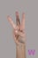 Human hand and three fingers up on grey background