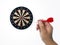 Human hand is throwing the darts target to the darts board. a man`s hand throws a dart at the target