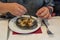 Human hand using small fork eating Escargots de Bourgogne