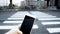 Human hand using smartphone at crosswalk when cross sign