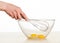 Human hand whisks eggs in glass blow