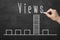 Human hand writing word Views on blackboard with chart bar showing the high rate of Views number for smm managers