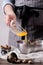 Human hands adding yolk from glass plate for making cookies