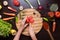 Human hands cutting tomato on cutting board and variation vegetables