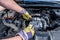 Human hands examining car engine in protective gloves close up