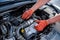 Human hands examining car engine in protective gloves close up