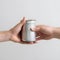 Human hands held metal cans between them. Concept about donation to homeless and sharing, on white background