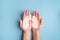 Human hands holding healthy lung shape made from paper on light blue background