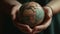 human hands holding a small globe