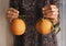 Human hands holding two oranges