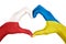 Human hands, painted with Poland and Ukraine flags,  forming heart shape