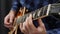 Human hands playing on guitar. Close up of male hands playing on electric guitar. Professional guitarist musician playing solo on