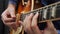 Human hands playing on guitar. Professional musician guitarist playing solo on electric guitar. Guitar music lessons. Male fingers
