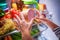 Human hands reaching for food at night in the open refrigerator