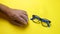 Human hands search, find and take eye glasses in blue plastic frame. On yellow background.