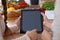 Human hands of two female persons using touchpad in the kitchen. Closeup of two women are making online shopping by