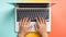 Human hands typing laptop keyboard, pastel background, top view
