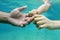 Human hands in underwater. Baby hand holding fathers finger. Underwater hands of father and small child in clear blue