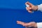 Human hands use spray, disinfectant, antiseptic in bubble, jar on blue background