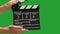 Human hands are using a clapperboard isolated on green screen. Beginning of scene in film or television production