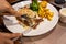 Human hands using knife and fork cutting delicious sirloin steak