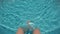 Human legs shaking water in swimming pool