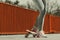 Human legs skater with skateboard on street.