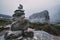 Human-made pile of stones - cairn as way marker in foggy mountain