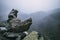 Human-made pile of stones - cairn as way marker in foggy mountain