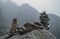 Human-made pile of stones - cairn as way marker in foggy mountain